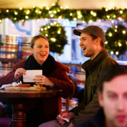 Two customers laughing, with another customer in the foreground