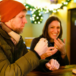 A male customer and two female customers eating pizza