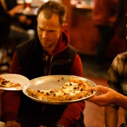 Customers sharing pizzas in the Franciscan Well which doesnt require advance table booking