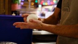 Pizzaiolo rolling a ball of pizza dough in his hands