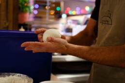 Pizzaiolo rolling a ball of pizza dough in his hands