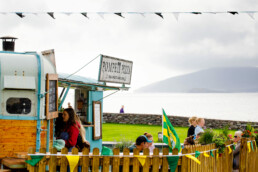 Customers at the Coffee & Gelato food trailer in Waterville, with the Pompeii Pizza mobile pizzeria trailer & sea view in the background