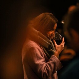 Sommelier tastes a glass of red wine as part of pizza pairing and wine tasting