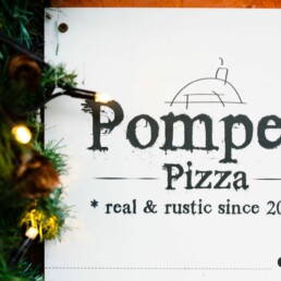 Pompeii Pizza gift voucher surrounded by christmas lights