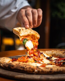 lifting a slice of the best pizza